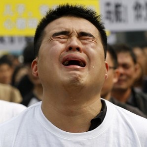 A family member of passenger on board Malaysia Airlines MH370 cries during protest in front of Malaysian embassy in Beijing