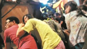 Tourists take cover on the floor next to an overturned table as armed men occupy a hotel in Sabah